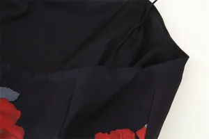 Close-up detail of floral print fabric and fine stitching on elegant black top