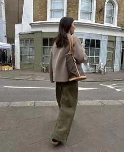 Vue arrière d'une femme en manteau de laine marron marchant dans une rue européenne