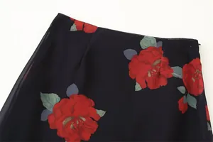 Close-up detail of a dark navy maxi skirt featuring large red rose floral prints