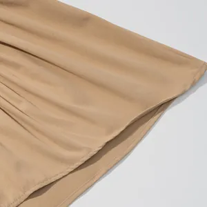 Close-up of beige pleated fabric with detailed hem stitching for a women's tank top
