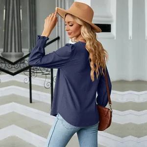 Detailed view of women's navy blue jacquard blouse with puff sleeves and smocked cuffs.