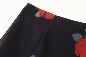 Close-up detail of elegant red rose floral print on lightweight black chiffon fabric