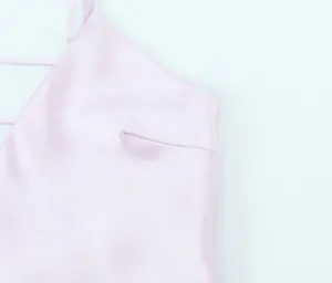 Detailed macro shot of premium pink satin fabric on a stylish V-neck slip midi dress
