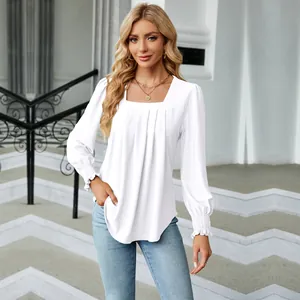 Close-up of elegant white square neck blouse with jacquard pleats and ruffled cuffs.