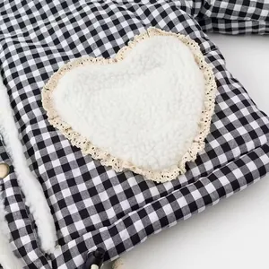 Close-up of heart-shaped sherpa patch with lace trim on checkered jacket