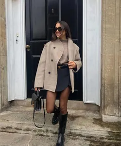 Manteau court en laine à double boutonnage de style britannique porté par un modèle