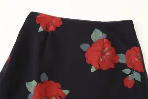 Close-up detail of elegant large red rose floral print on a dark breathable fabric skirt