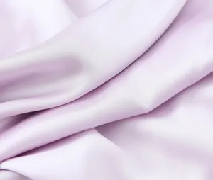 Close-up view of the smooth lavender silk satin fabric texture with elegant soft drapes