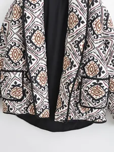Detail view of geometric print quilted jacket with fake two-piece design and black trim.