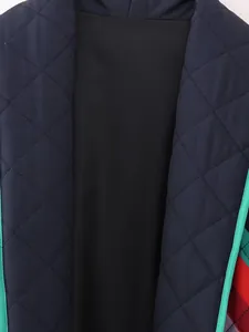 Close-up of quilted diamond pattern and mint green trim on navy cotton jacket