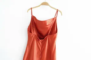 Détail d'une robe nuisette en satin orange rouille avec col bénitier et bretelles.