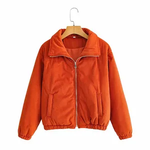 Detailansicht einer rostorangen Cord-Steppjacke mit Reißverschluss für Damen im Herbst.
