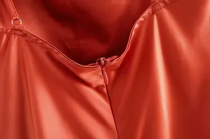 Détail en gros plan de la fermeture éclair invisible d'une robe nuisette en satin rouge