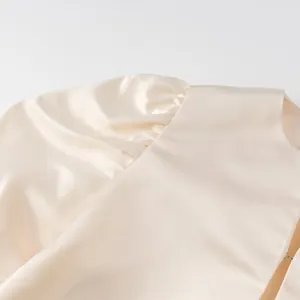 Close-up detail of champagne satin puff sleeve on a stylish cropped blouse