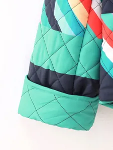 Detailed macro view of colorful geometric quilted sleeve on women's padded jacket