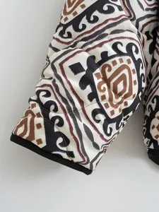 Close-up detail of ethnic geometric print on a quilted winter jacket sleeve with black cuff