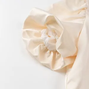 Detailed macro view of elegant cream satin puff sleeve with rich pleated texture