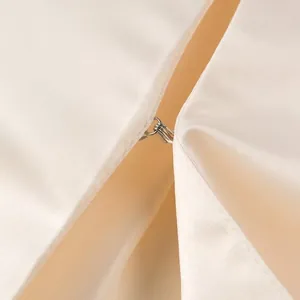 Close-up detail of hook and eye closure on elegant cream satin fashion cropped top