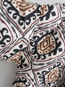 Close-up detail of ethnic geometric print and quilted stitching on a padded jacket