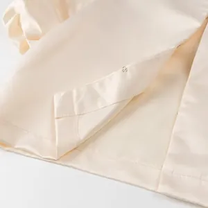 Macro view showing the hook-and-eye closure and silky texture of the satin top