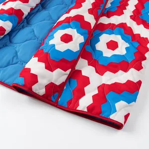 Detailed view of the geometric floral print and blue quilted lining of the kimono jacket.