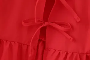 Gros plan détaillé du nœud papillon sur un chemisier rouge à manches bouffantes pour femme
