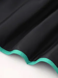 Detailed macro view of green contrast piping on black thin quilted women's cotton jacket