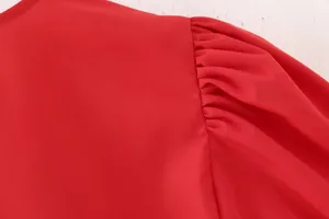 Gros plan détaillé de l'épaule bouffante d'un chemisier rouge et de sa texture