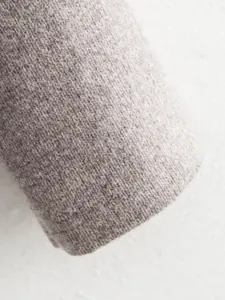 Macro view showing the soft grey knitted fabric texture of this elegant women's blazer jacket