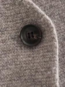 Macro view close-up showing soft knit fabric texture and dark marble button detail