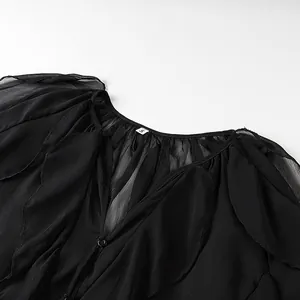 Detailed close-up showing the ruffled layers and V-neckline of this black sheer blouse
