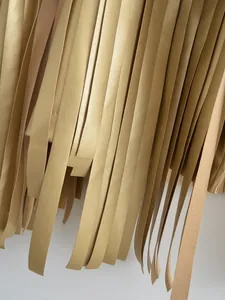 Close-up of golden metallic faux leather fringe tassels on a stylish fashion street jacket
