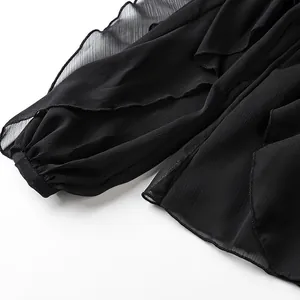 Close-up of black chiffon blouse showing elegant layered ruffles and sleeve texture