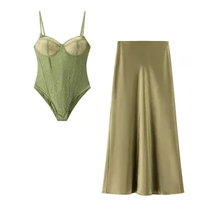 Detailed view of sage green lace corset bodysuit and matching satin midi skirt set.