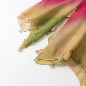 Detalle del dobladillo con volantes en un vestido de verano de gasa con degradado rosa y amarillo