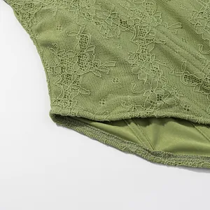 Detailed close-up showing the intricate floral lace texture and hem of a green corset top