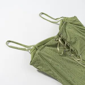Detail shot of a green floral lace corset top featuring delicate satin ribbon lacing