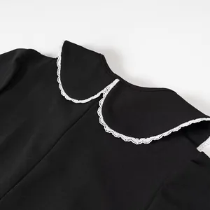 Detail view showing the detachable white lace Peter Pan collar on this black dress