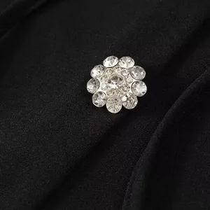 Exquisite close-up of sparkling rhinestone flower button on elegant black dress fabric