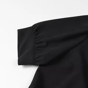 Detailed macro view of the pleated black sleeve cuff on a chic sweet doll collar dress.