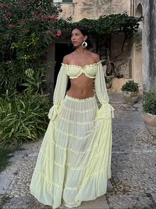 Elegant light yellow tiered skirt set worn in a scenic outdoor garden setting.