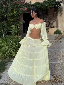 Close-up of a sexy yellow two-piece set featuring off-shoulder top and tiered maxi skirt.