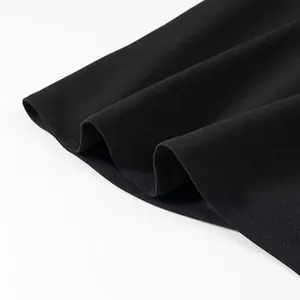 Close-up of black dress hem showing delicate fabric texture and professional stitching.