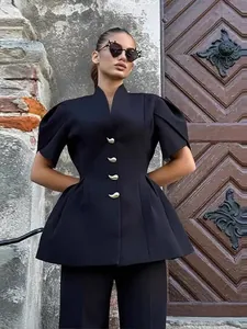 Elegante top a peplo nero con maniche a sbuffo e bottoni dorati in un set all'aperto