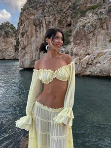 Detailed view of the yellow off-the-shoulder crop top and tiered maxi skirt set.