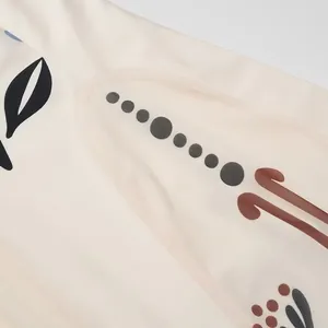 Gros plan d'une broderie florale ethnique sur un tissu de robe plissée en maille ivoire.