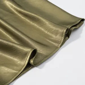High-quality close-up detail of the olive green satin skirt hem showing smooth texture and fine stitching.