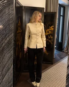 Close-up of elegant cream Chinese-style blazer with traditional frog buttons and stand collar