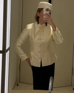 Detail of cream-colored blazer featuring a stand collar and traditional Chinese frog buttons
