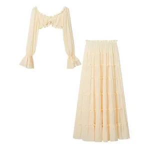 Two-piece cream clothing set featuring off-shoulder top and tiered maxi cake skirt